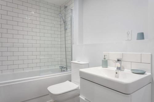 a white bathroom with a toilet and a sink at Stunning 2br Flat in the Centre of Birmingham in Birmingham