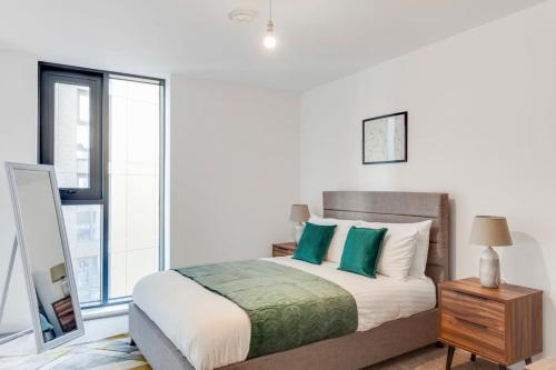 1 dormitorio con 1 cama grande con almohadas verdes en Modern & Stylish 1Bed Flat in Central Birmingham, en Birmingham