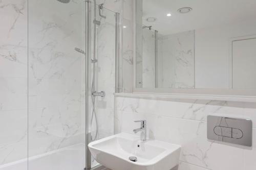 y baño blanco con lavabo y ducha. en Modern & Stylish 1Bed Flat in Central Birmingham, en Birmingham