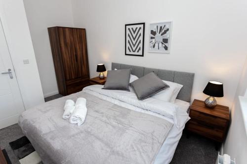 a bedroom with two beds with white sheets and pillows at Modern 1 Bedroom Apartment in Bolton in Bolton