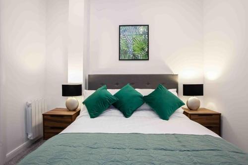 a bedroom with a large bed with green pillows at Modern & Stylish 1 Bedroom Apartment in Bolton in Bolton