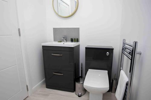 a bathroom with a sink and a toilet and a mirror at Modern & Stylish 1 Bedroom Apartment in Bolton in Bolton
