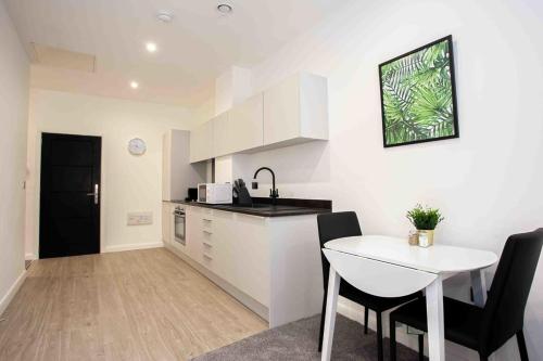 a kitchen and dining room with a table and chairs at Modern & Stylish 1 Bedroom Apartment in Bolton in Bolton