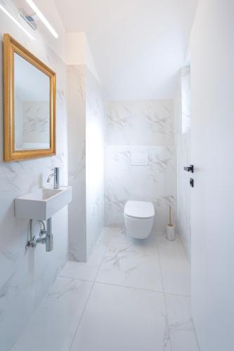 a white bathroom with a sink and a toilet at Sunny Hill Apartment in Ilirska Bistrica