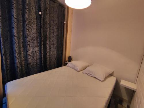 un lit avec deux oreillers dessus dans une chambre dans l'établissement Studio Cabine Rénové, Terrasse et Parking, à 500m de la Plage - FR-1-776-61, à Argelès-sur-Mer