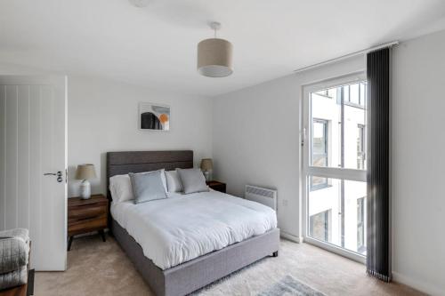 a bedroom with a bed and a large window at Spacious 1 Bedroom Apartment in a Converted Mill in Leeds