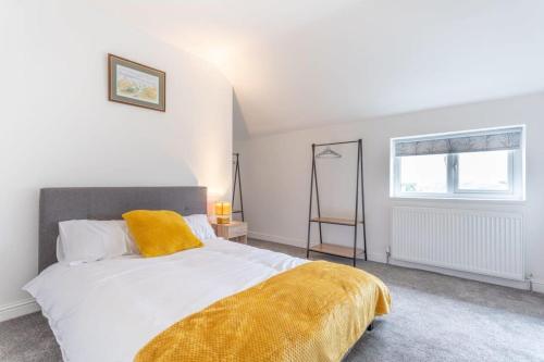 Un dormitorio con una cama con una manta amarilla. en Lovely 2 Bed apartment close to city centre en Bradford