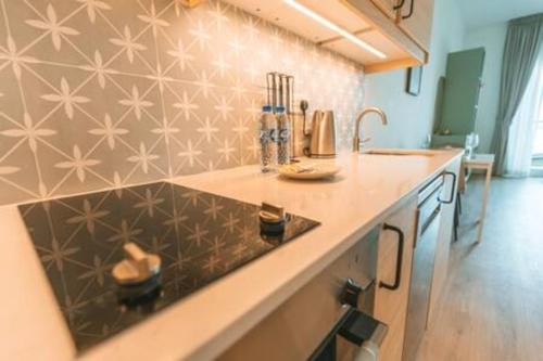 a kitchen with a counter top and a sink at Cozy Chic Studio with Balcony The Greens Dubai in Dubai