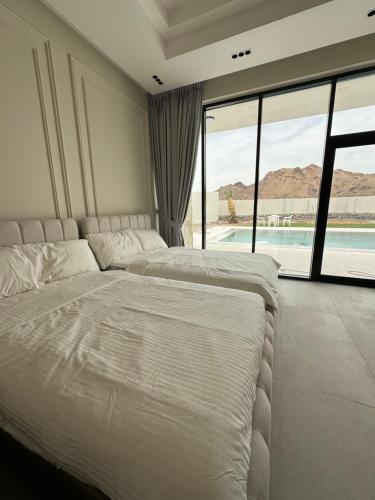 a bedroom with two beds and a view of a pool at Alreef farm in Ras al Khaimah