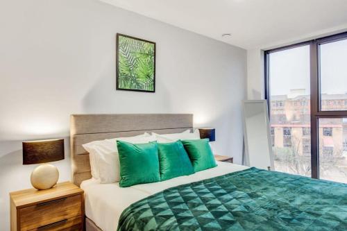 een slaapkamer met een groot bed met groene kussens bij Stylish and Beautiful 1 Bedroom Flat in Birmingham in Birmingham