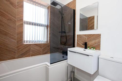 a bathroom with a toilet and a sink and a window at Modern 2 Bedroom Apartment in Bolton in Bolton