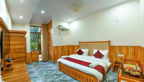 a bedroom with a large bed in a room at Jims Gateway Hotel And Restaurant in Rāmnagar