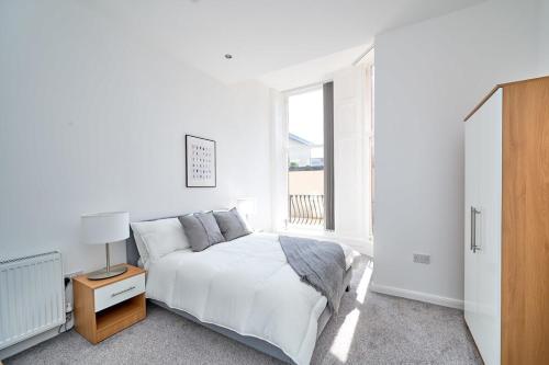 a white bedroom with a bed and a window at Modern 2 Bedroom Apartment in Preston in Preston