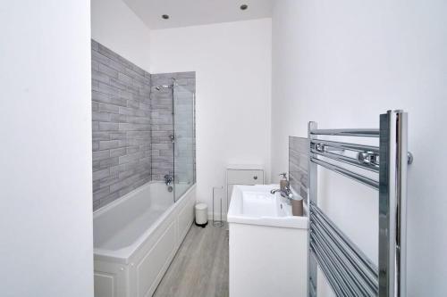 a white bathroom with a tub and a sink at Modern 2 Bedroom Apartment in Preston in Preston