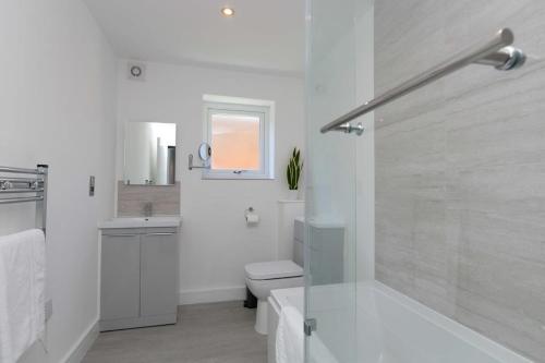 a bathroom with a shower and a toilet and a sink at Stunning 2 Bedroom Apartment in Wallasey in Wallasey