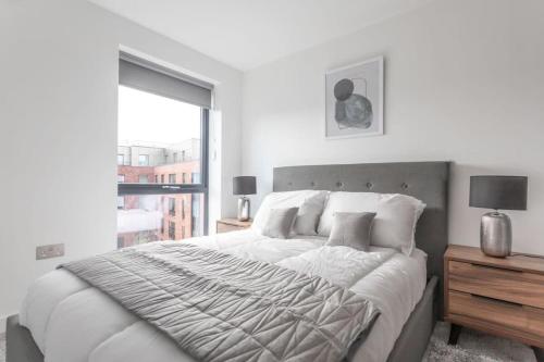Un dormitorio blanco con una cama grande y una ventana. en StayZeni, Ouse Court York Smart 2 Bed Flat, en York