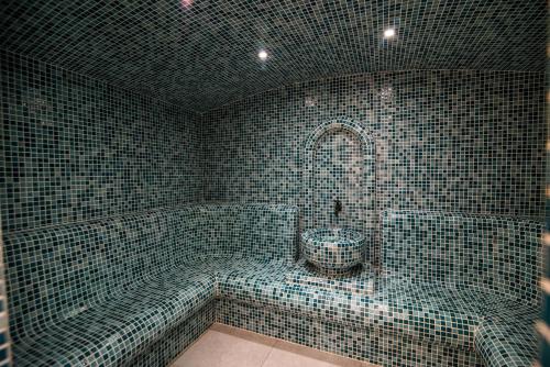 a tiled bathroom with a tub and a toilet at Dishli Hotel & Spa in Struga