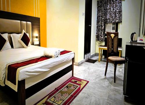 a hotel room with a bed and a chair at STAYMAKER The Altira in Jamshedpur