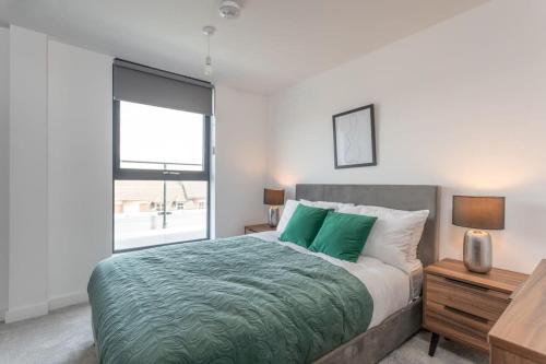 Un dormitorio con una cama con sábanas verdes y una ventana en Amazing 2 bed Apartment with Roof Terrace in the heart of York, en York