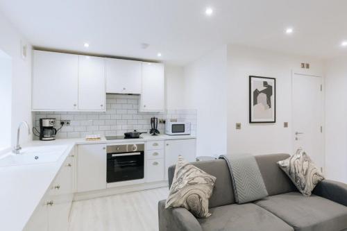 a living room with a couch and a kitchen at Central Ipswich Modern Budget 1 Bed Apartment in Ipswich