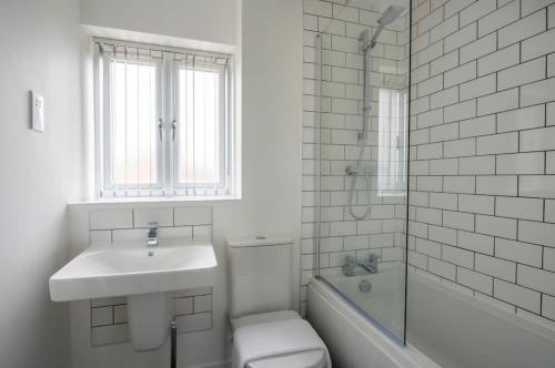 a bathroom with a sink and a toilet and a shower at Lovely brand new 3 bedroom city centre house with garden in Derby
