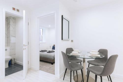 a white dining room with a glass table and chairs at Centrally Located 1 Bedroom Apartment in Ipswich in Ipswich