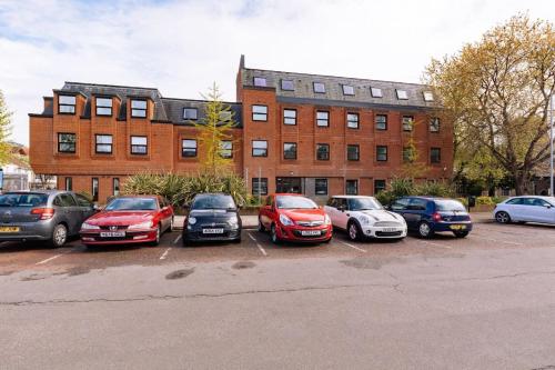 a group of cars parked in a parking lot in front of a building at Central Ipswich Modern Budget 1 Bed Apartment in Ipswich