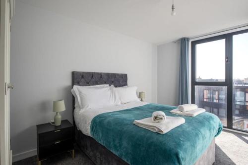 a bedroom with a bed with towels on it at Superb 2 Bedroom Aparttment in Central Birmingham in Birmingham