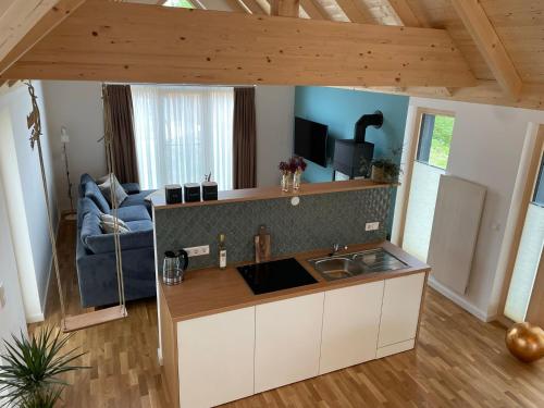 a kitchen with a sink and a living room at Waidlerland Waldkirchen Chalets in Waldkirchen