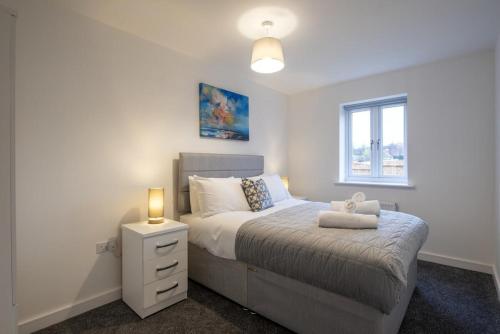 een slaapkamer met een bed en een raam bij Modern 3 Bedroom House in Central Derby in Derby