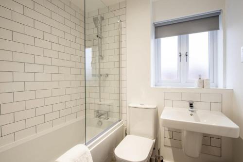 a bathroom with a toilet and a sink and a shower at Modern 3 Bedroom House in Central Derby in Derby