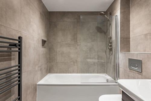 uma casa de banho com uma banheira branca e um chuveiro em Stunning Modern 2 Bedroom Apartment in York em York