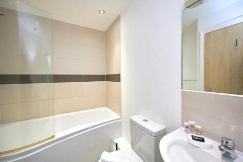 a bathroom with a toilet and a tub and a sink at Lovely 2 Bedroom Apartment in Preston in Preston