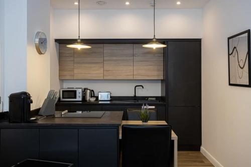 a kitchen with a sink and a counter top at Contemporary Bolton Apartment in Central Location in Bolton