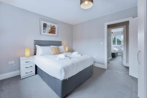 a bedroom with a large bed and a bathroom at Spacious 3 Bedroom House with Garden in Birmingham in Birmingham