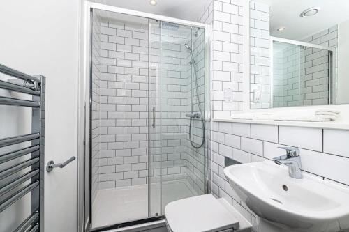 ein Bad mit einem WC, einem Waschbecken und einer Dusche in der Unterkunft Stylish 2 Bedroom Apartment by Old Trafford in Manchester