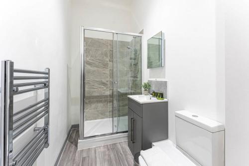 a white bathroom with a shower and a toilet at Modern 1 Bedroom Apartment in Dudley in Brierley Hill