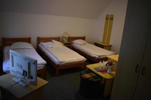 una camera d'albergo con due letti e un monitor per computer di Alesiv a Cluj-Napoca