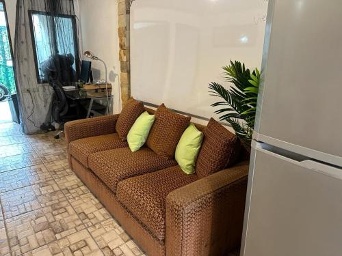 Casa Colibrí في سان خوسيه: أريكة بنية مع وسائد صفراء في غرفة المعيشة