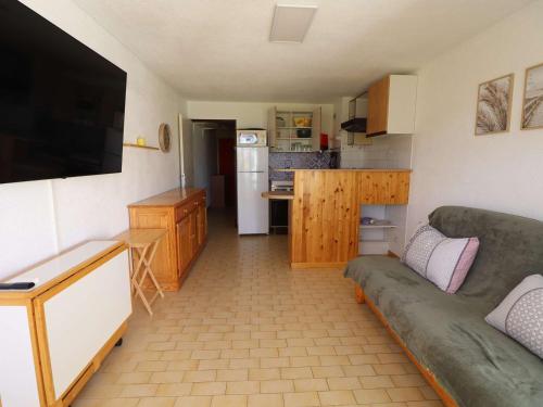 un salon avec un canapé et une cuisine dans l'établissement Appartement 2 Pièces Cabine en Rez-de-Jardin avec Parking, à 300m de la Plage, Animaux Admis - FR-1-307-257, au Grau-du-Roi
