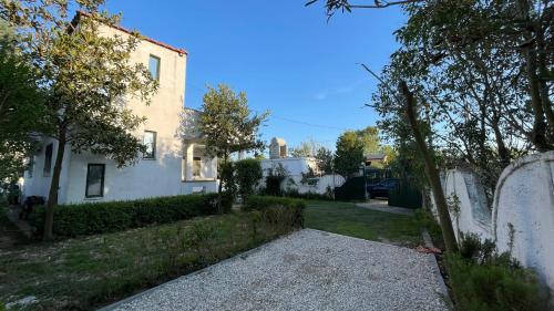ein weißes Haus mit einem Zaun und einem Hof in der Unterkunft Gerea's Holiday House in Durrës