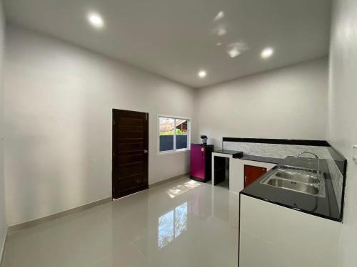a white kitchen with a sink and a window at Family house villa in Ban Khlong Khamao (2)