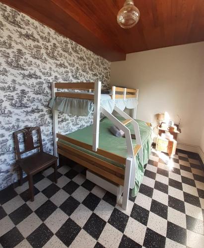 a bedroom with two bunk beds and a chair at Maison Bienvenue chez Mémé in Treigny