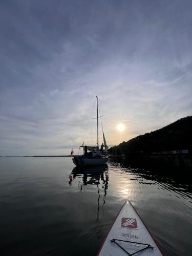 un barco sentado en el agua junto a un barco en Loď u Jančúra, en Kaluža