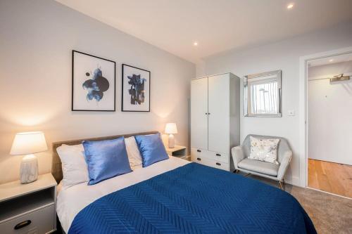 a bedroom with a blue bed and a chair at Cosy 1 Bedroom Apartment in the Heart of Eastleigh in Eastleigh