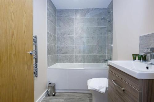 uma casa de banho com uma banheira, um WC e um lavatório. em Modern and Stylish 1 Bed Apartment Manchester em Manchester
