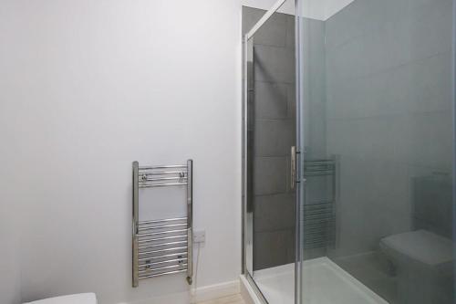 uma casa de banho com uma cabina de duche em vidro e um WC. em Contemporary 1 Bed Apartment Central Bolton em Bolton