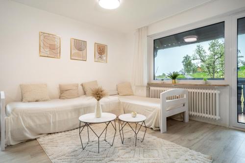 un soggiorno bianco con divano e tavolo di Ferienwohnung Achraintal 3 a Lindau