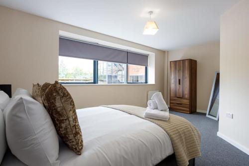 Un dormitorio con una gran cama blanca y una ventana en Modern 2 Bedroom Apartment Manchester en Mánchester