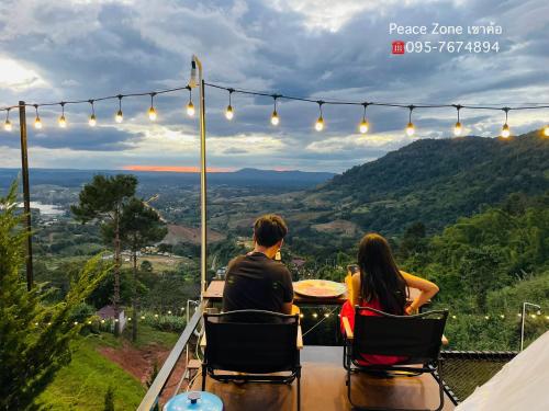 閣考島的住宿－Peace Zone เขาค้อ，一对夫妇坐在桌子上,眺望着群山